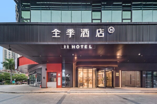 A hotel entrance with a modern design, featuring a prominent sign with Chinese characters and the English name "JI HOTEL". - Ji Hotel Shenzhen Baoan Pingzhou Subway Station (Shenzhen)