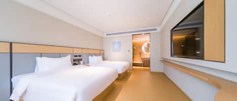 Une chambre d’hôtel avec deux lits, un grand miroir et une télévision.