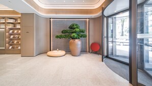 A modern lobby with a central plant display, a seating area, and a glass entrance. - Ji Hotel Shenzhen Baoan Pingzhou Subway Station (Shenzhen)