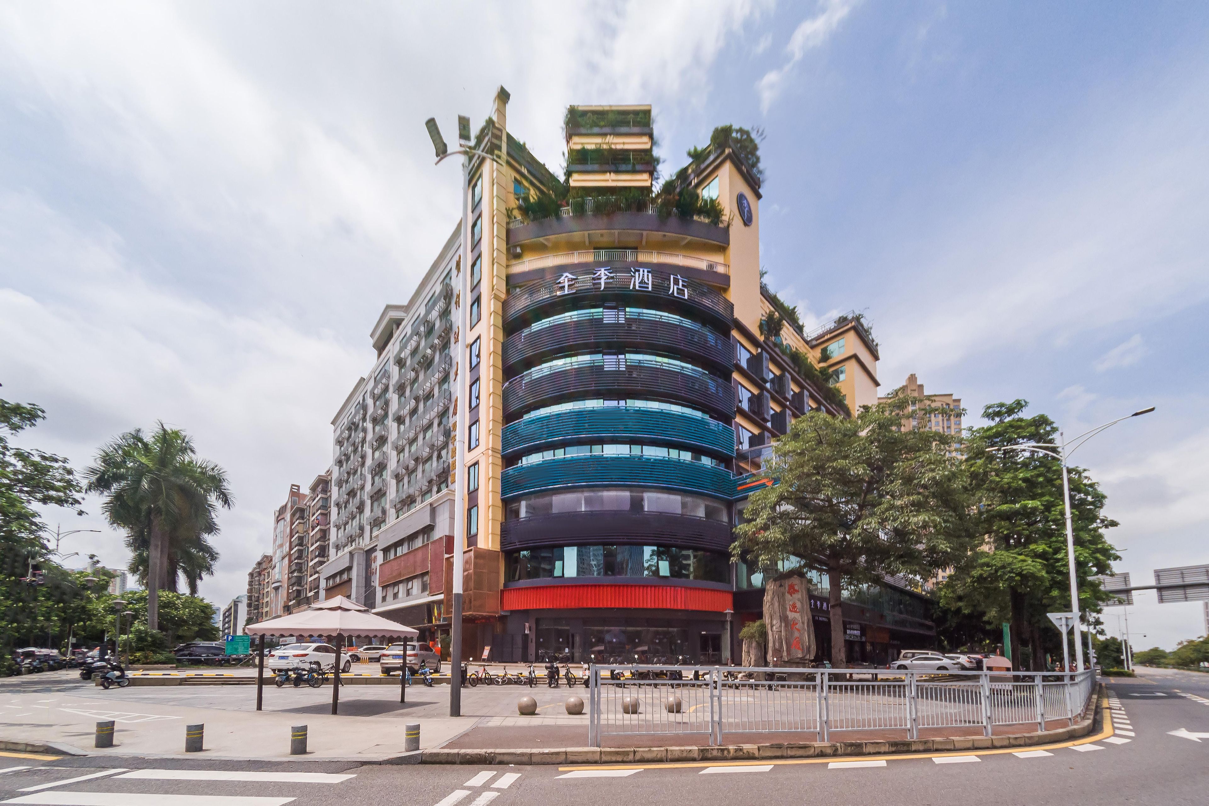 Un hotel de varios pisos con un diseño moderno, que cuenta con balcones y una entrada destacada.