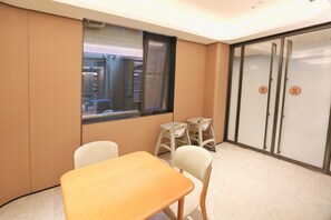 A conference room with a wooden table, two chairs, a window, and a sliding door with a 'pull' sign. - Ji Hotel Shenzhen Baoan Pingzhou Subway Station (Shenzhen)