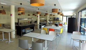 A cafeteria with white tables and chairs, a food service area with a counter, and hanging wooden lamps. - VVF Villages Montagnac (Montagnac)