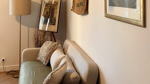 Une pièce confortable avec un canapé, une lampe, un tableau encadré et une décoration murale.
