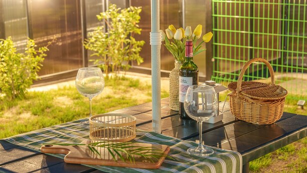 A table set outdoors with a bottle of wine, a glass, a basket, and a bottle opener. - Gyeongsan Stage-ipple pet Pension (Gyeongsan)