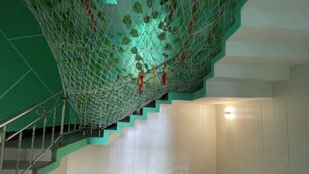 A staircase with a green netted structure above it. - Yijia Business Hotel (Guilin North Railway Station) (Guilin)