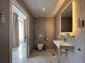 Un baño moderno con inodoro, lavamanos y ducha.
