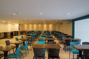 Una sala de conferencias con mesas y sillas dispuestas para reuniones.