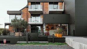 A modern two-story building with a brick facade, large windows, and a balcony. - CC Nomie Hôtel Restaurant (Dinant)