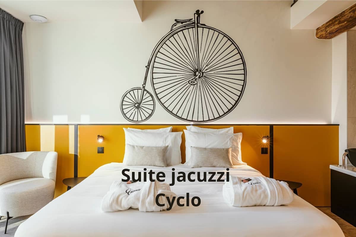 A hotel room with a bed, a chair, and a wall-mounted bicycle decoration.