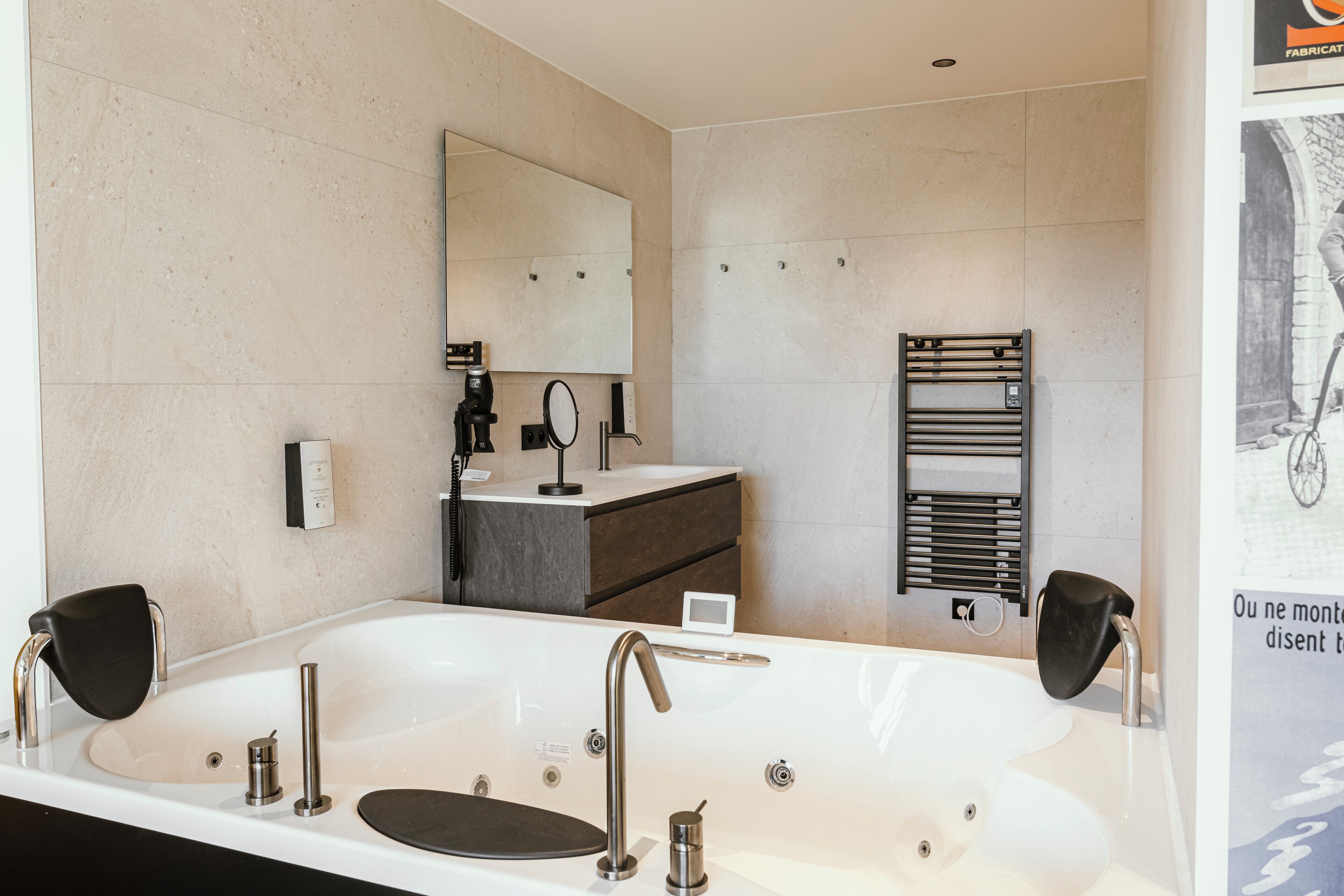 Un bagno moderno con una vasca da bagno ampia, uno specchio, un portasciugamani e un lavandino.