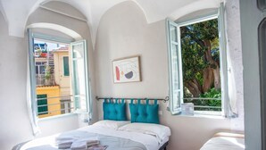 A bedroom with a bed, a window, and a wall-mounted picture. - La Terrazza Del Nonno With Sea-view Terrace (Sanremo)
