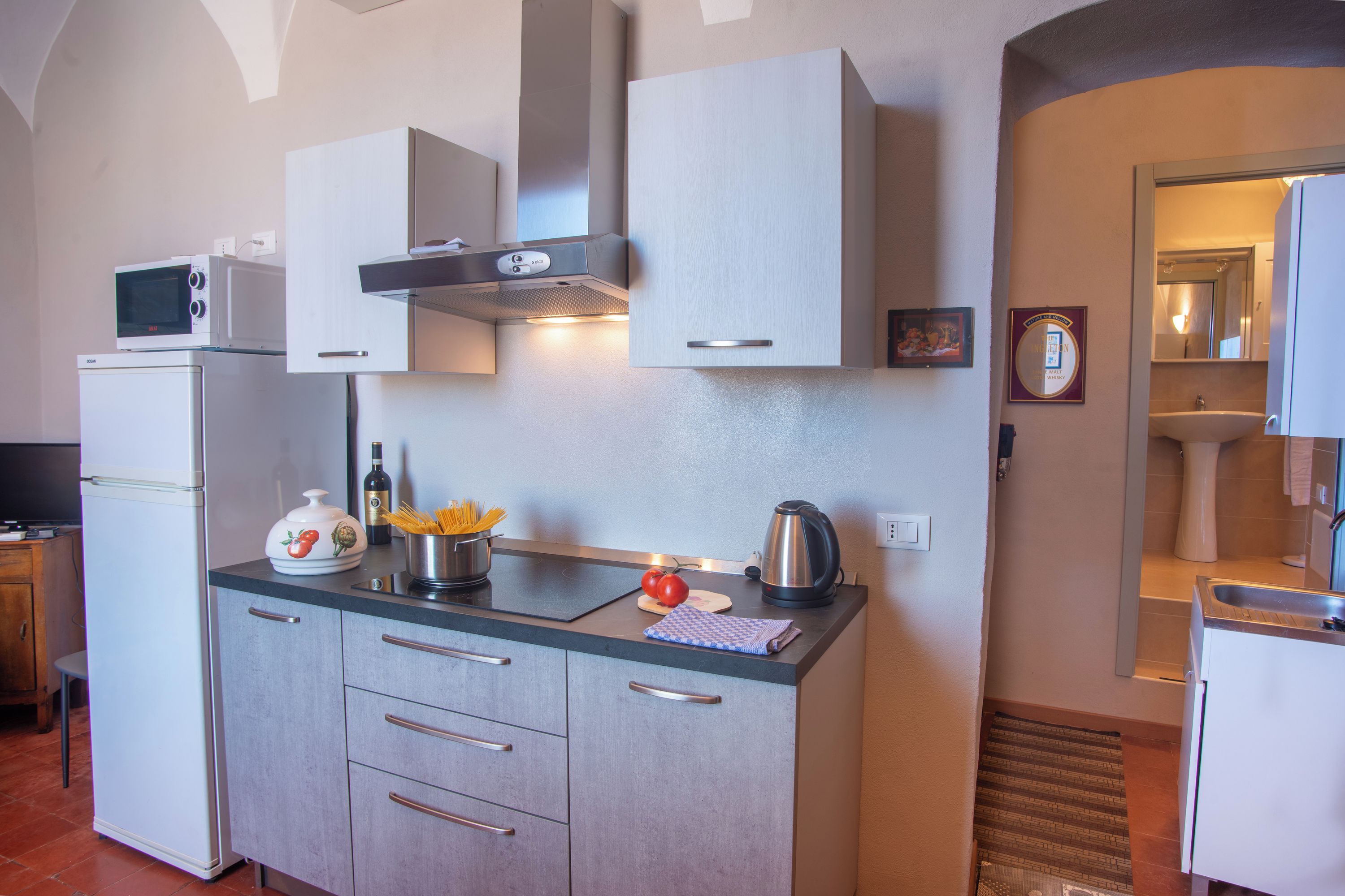 A compact kitchen with a microwave, stove, and cabinets.