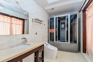 A bathroom with a sink, mirror, shower, and toilet.