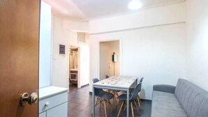 A compact living space with a dining area, a sofa, and a kitchenette. - Perfect choice for your stay in central Athens (Athina)