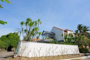 A modern house with a white exterior, a sloped roof, and a glass facade. - Namaya Villa Senggigi by The Lavana (West Lombok Regency)