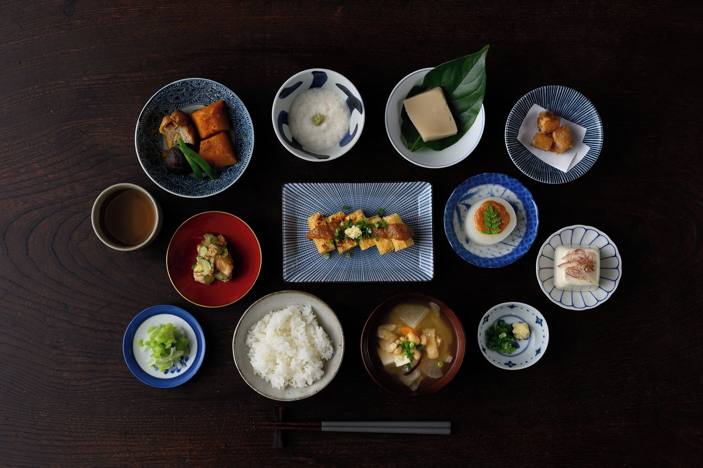 Ett urval av japanska rätter presenterade på ett mörkt träbord.