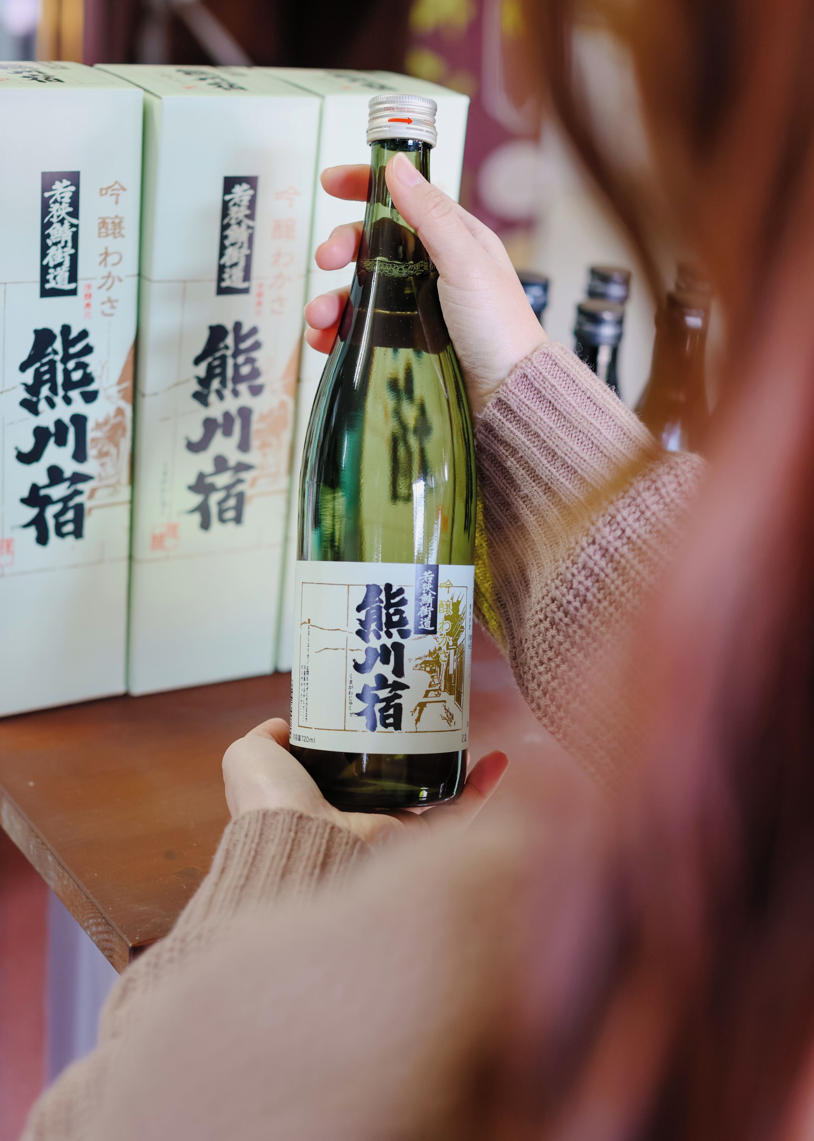 Una persona agafa una ampolla amb text japonès a l'etiqueta.