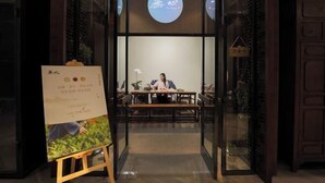 A reception area with a receptionist desk, a menu stand, and a glass partition. - Jinke Saint Hotel (Wuxi)