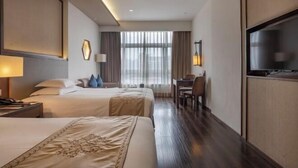 A hotel room with two beds, a desk, a chair, a television, and a large window with curtains. - Jinke Saint Hotel (Wuxi)