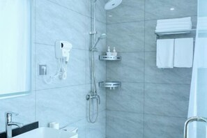 Ένα σύγχρονο μπάνιο με ντους, στεγνωτήρα χεριών και κρεμάστρα για πετσέτες.
