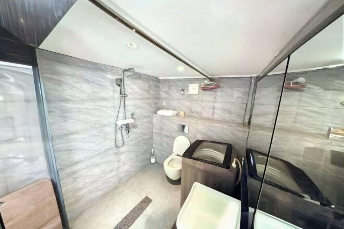 Une salle de bain moderne avec une douche à parois de verre, des toilettes et un lavabo.