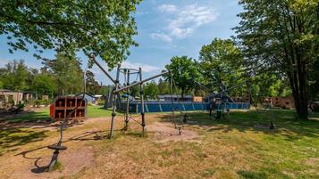 A playground with various play structures including swings and climbing frames.