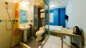 Un baño moderno con cabina de ducha de vidrio, un inodoro y un lavamanos.