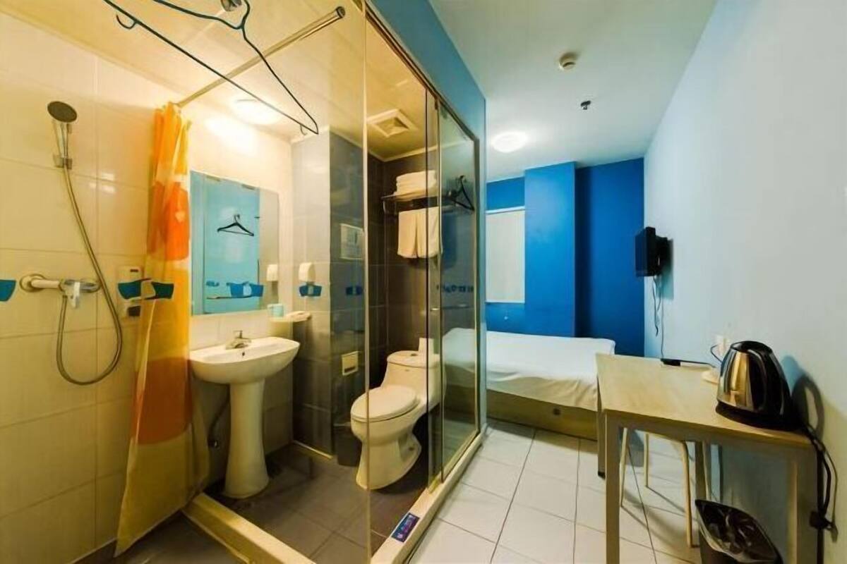 A modern bathroom with a glass shower enclosure, a toilet, and a sink.
