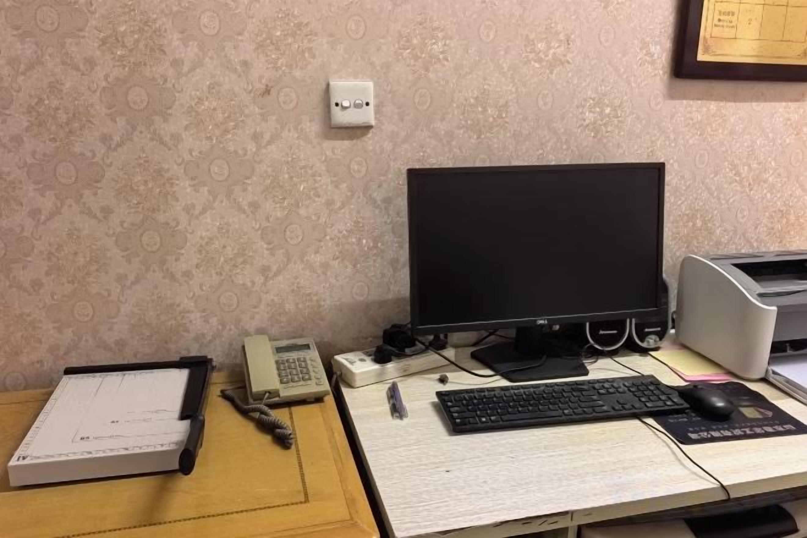 A desk with a computer monitor, keyboard, mouse, and a telephone.