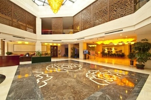 A spacious lobby with a marble floor, a reception desk, and a staircase leading to an upper level. - Mudan Hotel (Heze)