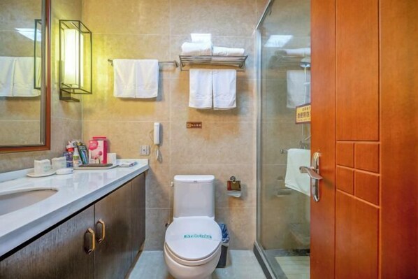 A modern bathroom with a toilet, sink, and glass shower enclosure. - Mudan Hotel (Heze)