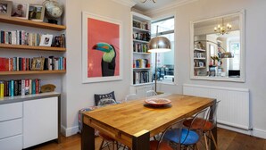 A dining area with a wooden table, chairs, and a globe on a shelf. - Thames-side Retreat, by Veeve (London)