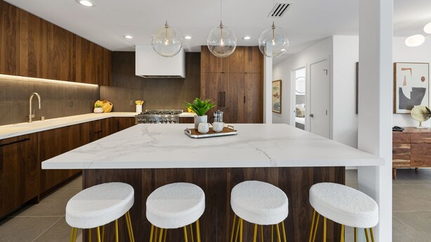 A modern kitchen with a large island, wooden cabinets, and pendant lighting. - Newly renovated 4-bedroom house with pool and two main suites in Palm Springs.  (Palm Springs)
