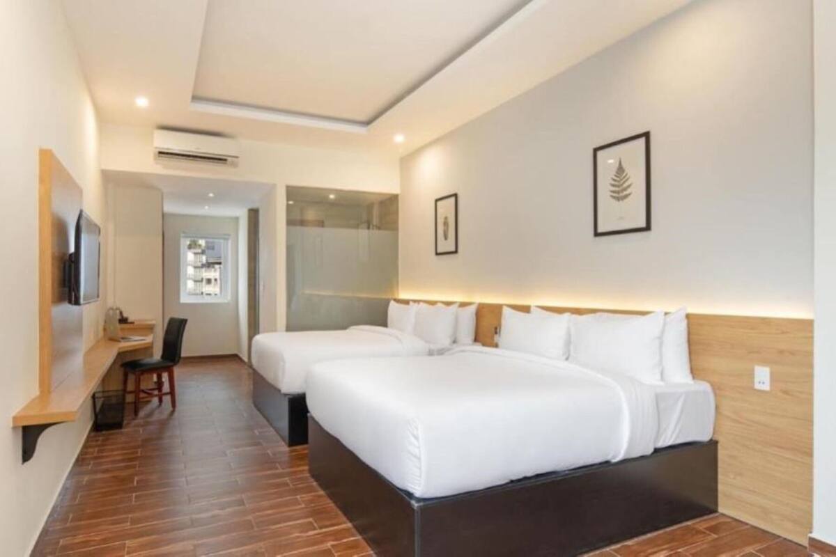 Een hotelkamer met twee bedden, een bureau, een stoel en een televisie.