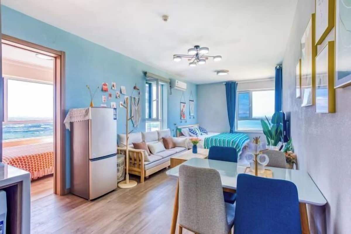 Una sala de estar moderna con sofá, mesa de comedor y zona de cocina.