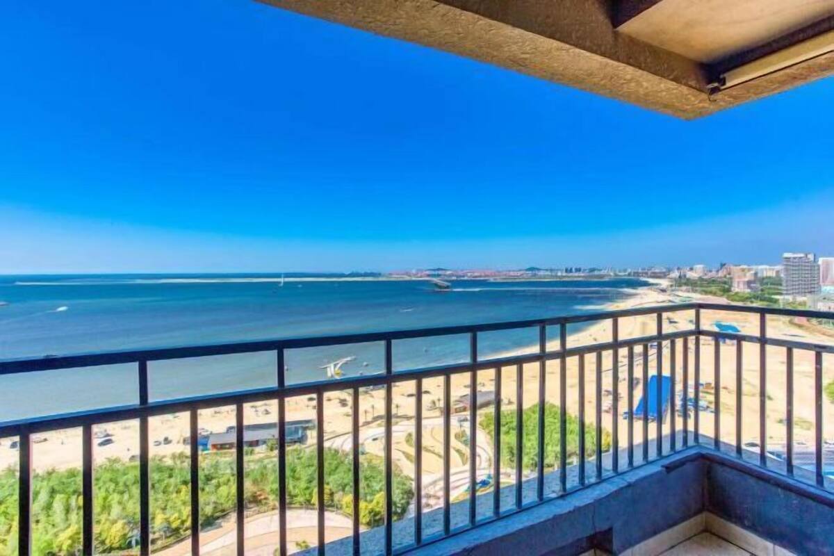 Un balcón con vista a la playa y al paisaje urbano.