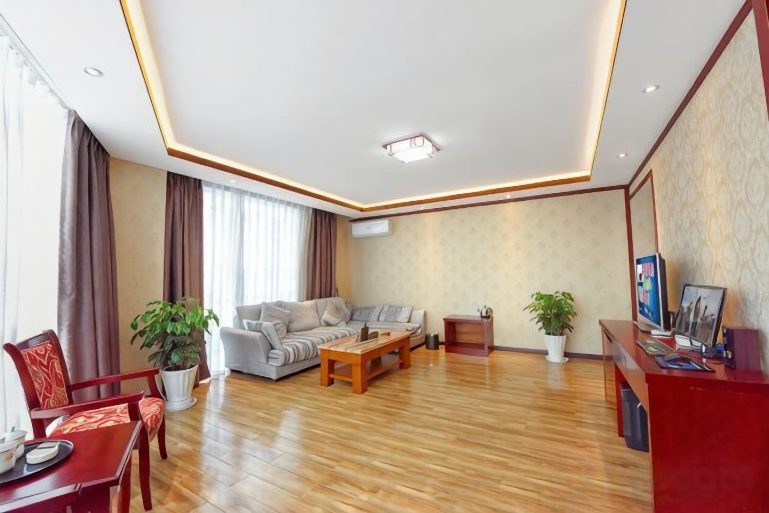 Una sala de estar moderna con un conjunto de sofás, una mesa de centro y un mostrador de recepción rojo.
