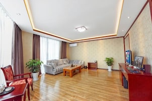 Una sala de estar moderna con un conjunto de sofás, una mesa de centro y un mostrador de recepción rojo.