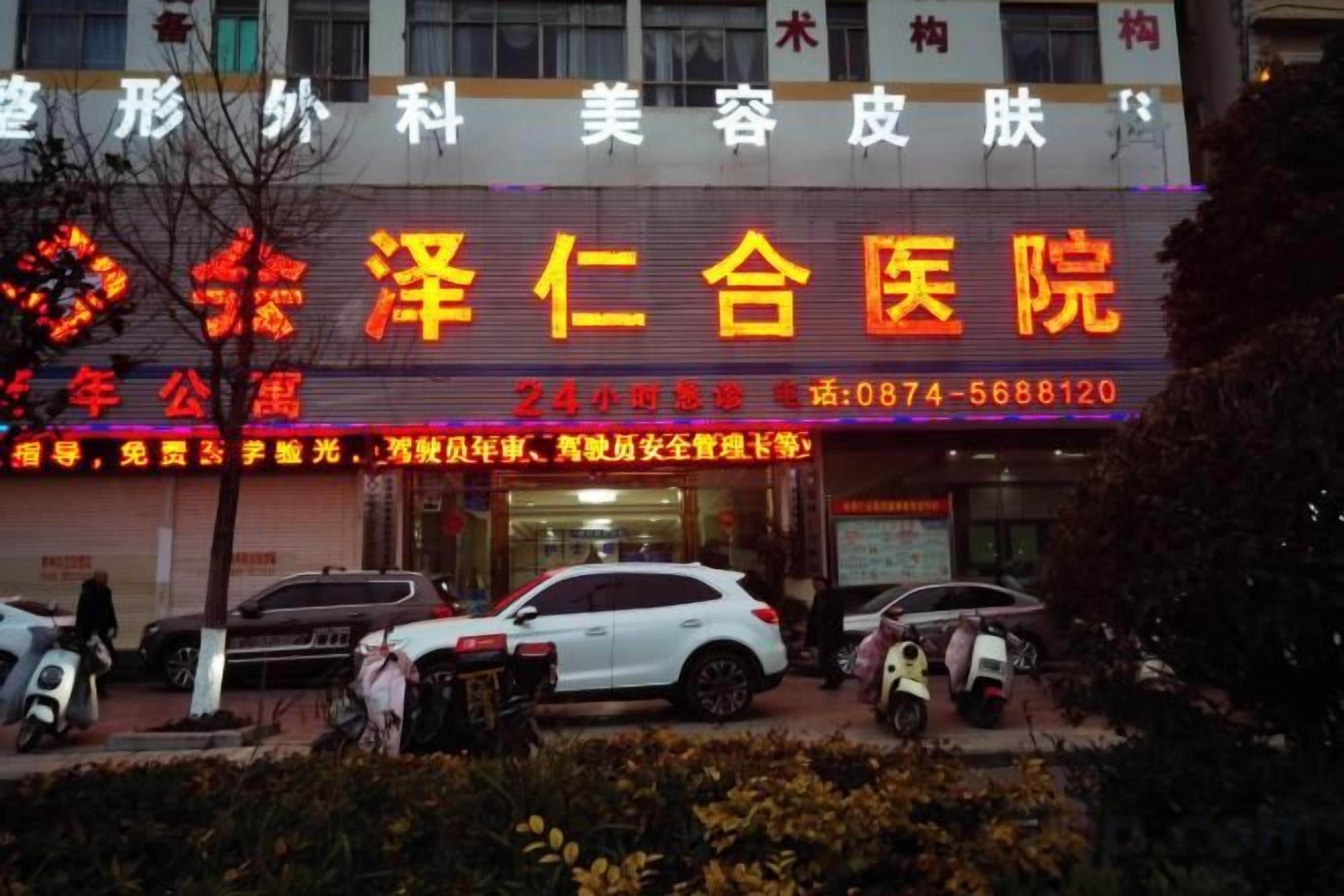 A building with a large sign indicating a medical facility. There are cars parked in front, and the entrance is visible.