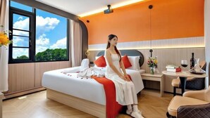 Una moderna camera d'albergo con un grande letto, un comodino con una lampada e vista sul cielo attraverso una finestra.