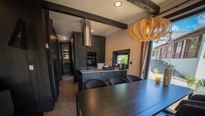 Una cocina moderna con armarios oscuros, una isla central y una lámpara colgante.