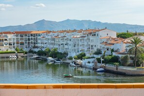 Un pueblo costero con edificios blancos, un puerto deportivo y barcos.