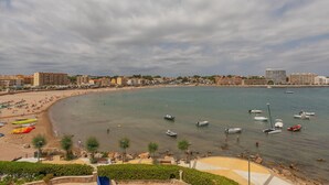 A coastal beach with boats, umbrellas, and a promenade. - Flateli l'Escala Vista Mar (L'Escala)