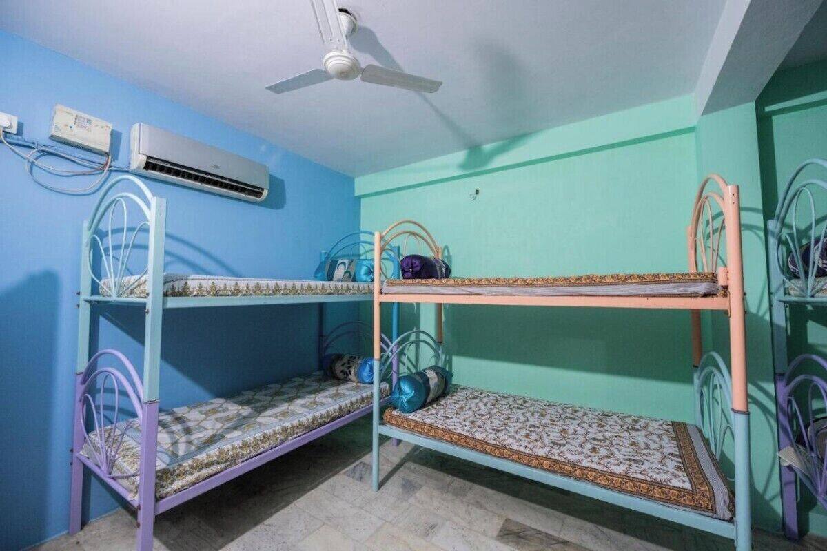 A bunk bed room with an air conditioning unit and a ceiling fan.