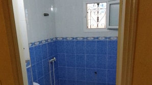 A bathroom with blue tiles, a white sink, a toilet, and a shower. - Dar Mourad (Djerba Midun, Médenine)