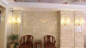 A lobby with two wooden chairs, a small table, and wall sconces. - Q+ Maoming Daxi Holiday Hotel (Maoming)