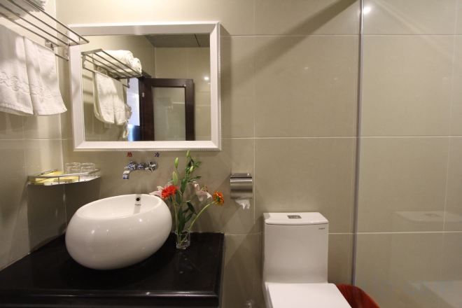 A bathroom with a white sink, a mirror, and a toilet.