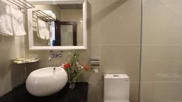 A bathroom with a white sink, a mirror, and a toilet.