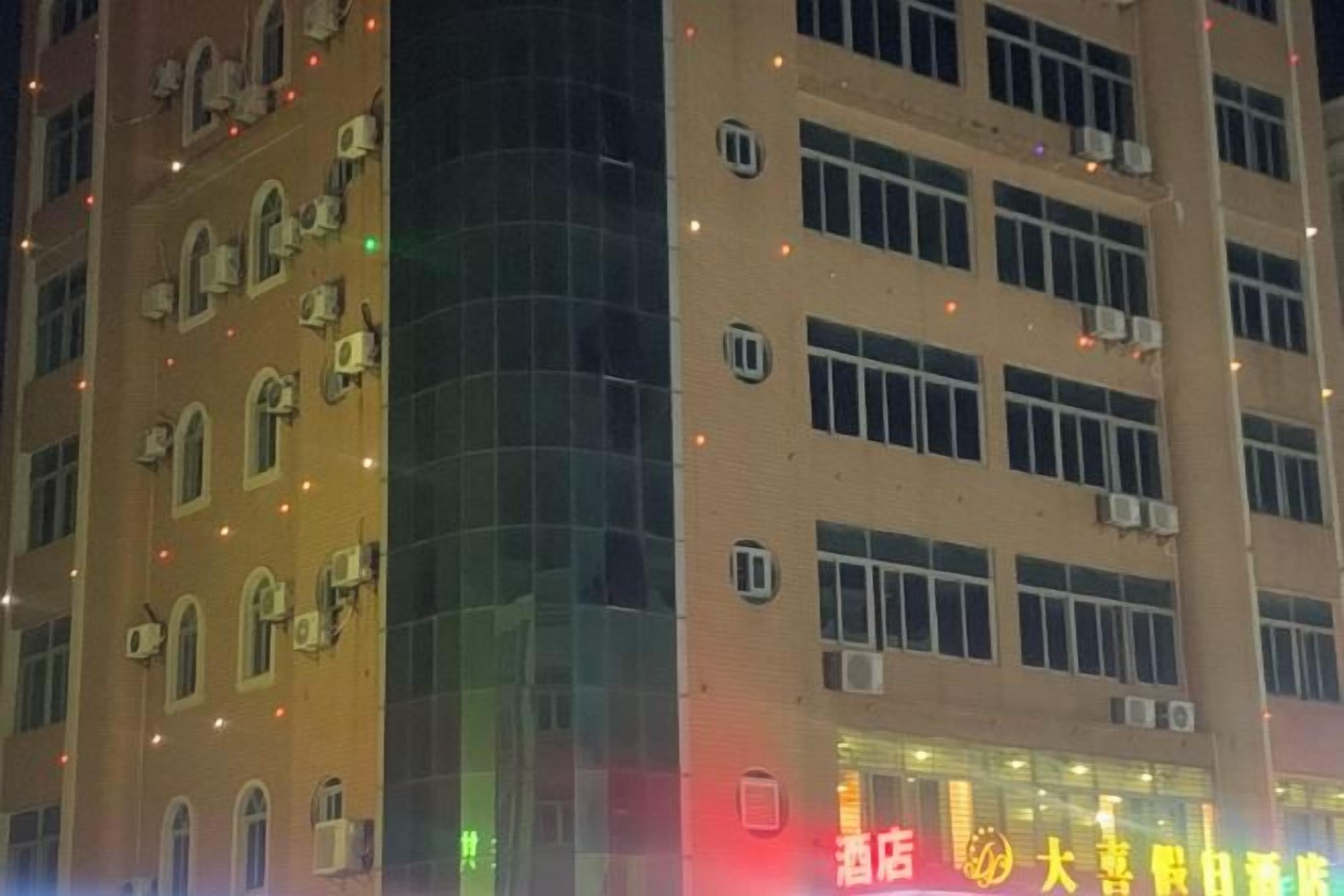 A multi-story building with a curved facade, multiple windows, and air conditioning units.