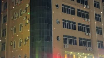 A multi-story building with a curved facade, multiple windows, and air conditioning units.